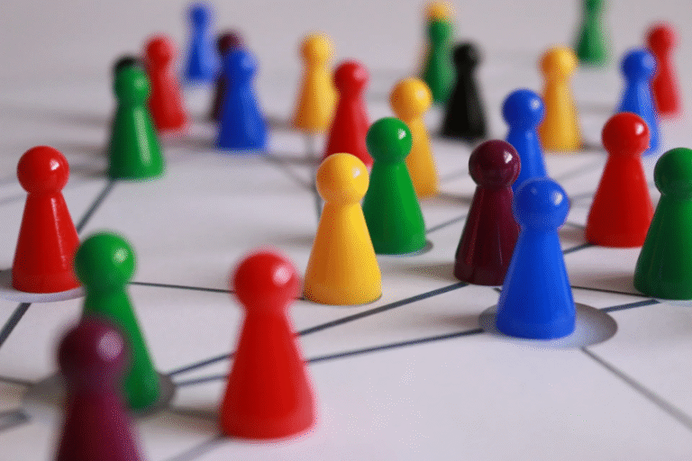 Bunte Spielfiguren auf Liniennetz – Symbol für Rollen, Strukturen und Beziehungen im Organisationsdesign.