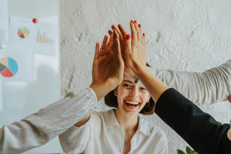 Team-High-Five als Symbol für Zusammenarbeit und Mitbestimmung in der Soziokratie.