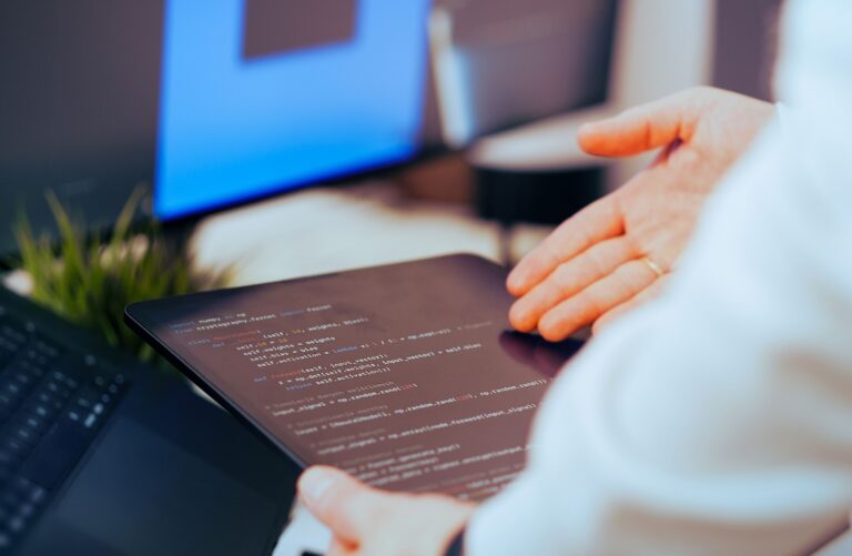 Mitarbeiter analysiert Code auf einem Tablet im Kontext der KI-Transformation